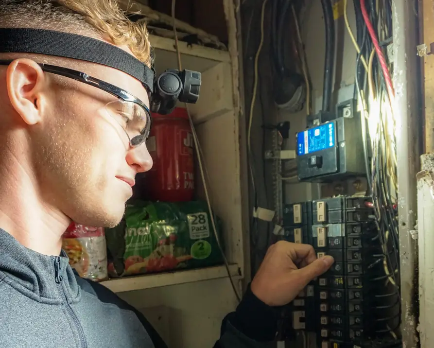 Justin from Bigfoot Electric working inside an open residential breaker panel